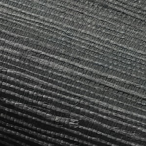 May include: Close-up of a black woven fabric with a textured surface. The fabric has a grid-like pattern and appears to be made of natural fibers.