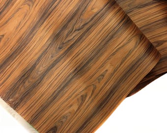 May include: Close-up of a sheet of wood veneer with a dark brown and light brown striped pattern.