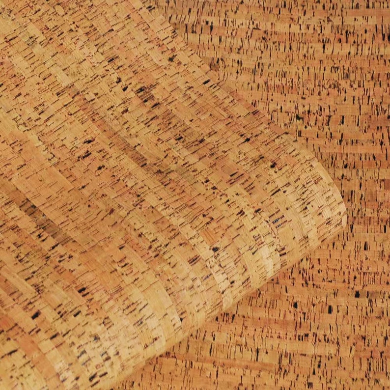 May include: Close-up of a sheet of cork with a natural brown colour and a textured surface. The cork is made up of small, irregular pieces that are tightly packed together.