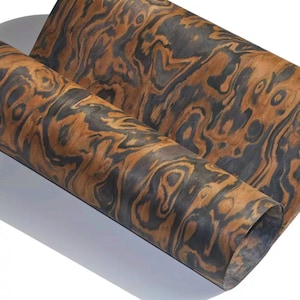 May include: A sheet of wood veneer with a distinctive brown and black wood grain pattern. The veneer is rolled up and has a natural, organic look.