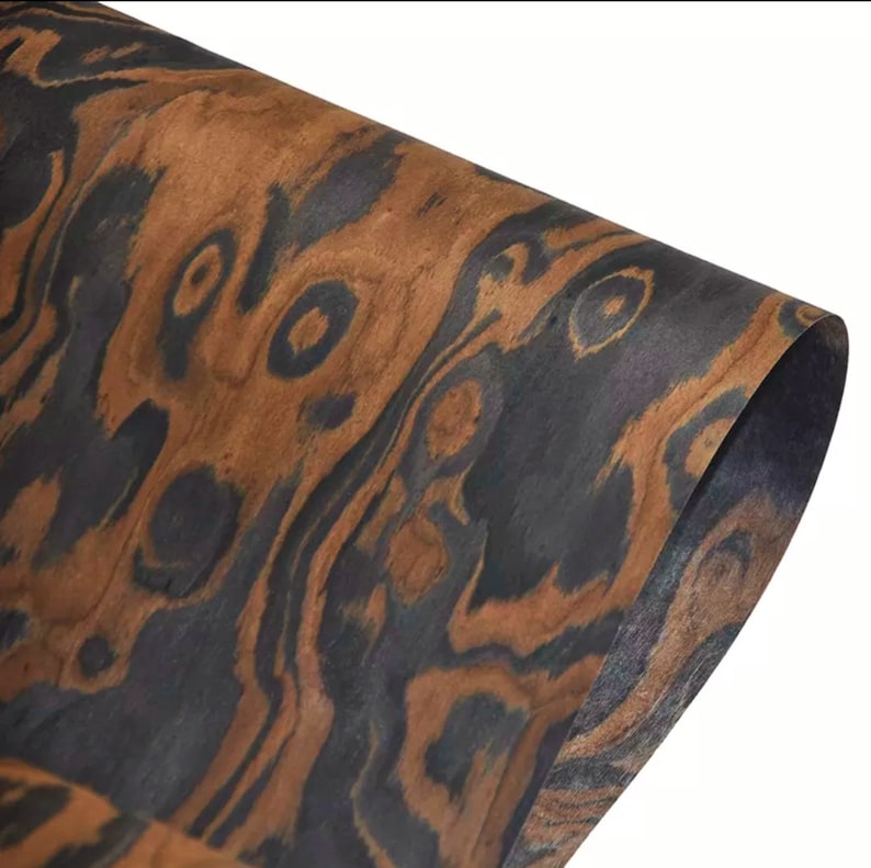 May include: Close-up of a sheet of wood veneer with a dark brown and black wood grain pattern. The veneer has a natural, organic look and feel.