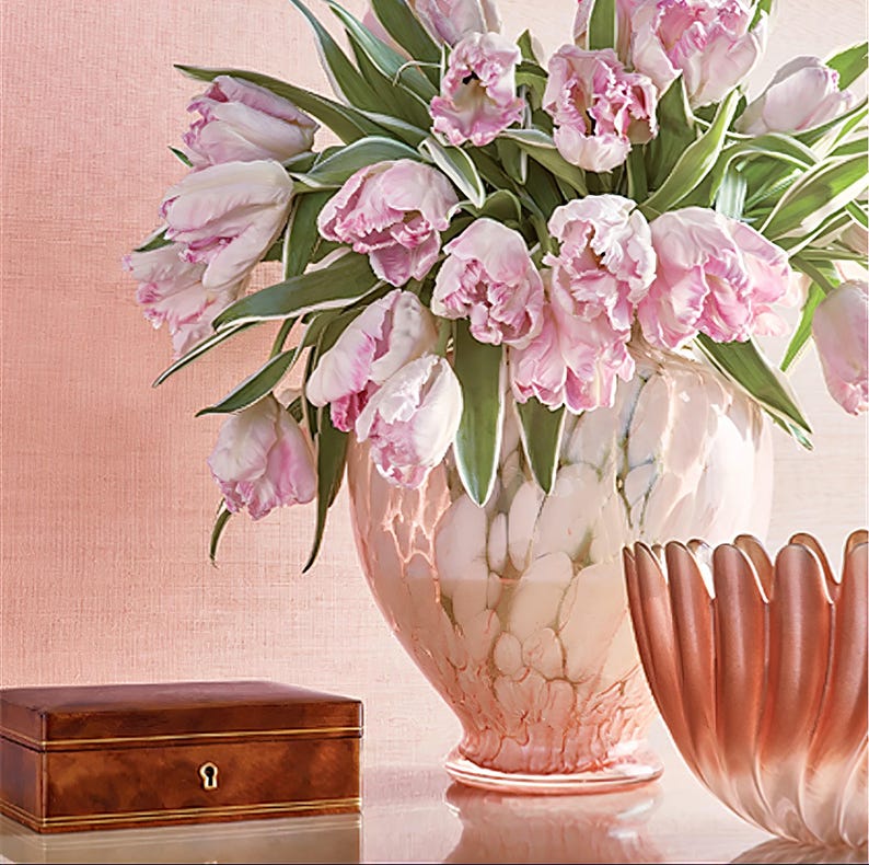 Puede incluir: Un ramo de tulipanes rosas en un jarr&oacute;n de m&aacute;rmol rosa y blanco. El jarr&oacute;n est&aacute; sobre una mesa con una caja de madera y un cuenco rosa.