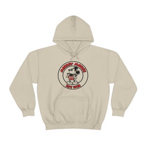 May include: A beige hoodie featuring a black and red Mickey Mouse logo with the text "Mickey Mouse Est 1928".