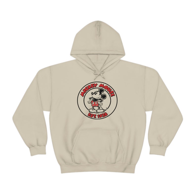May include: A beige hoodie featuring a black and red Mickey Mouse logo with the text "Mickey Mouse Est 1928".
