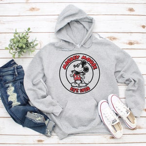 May include: A grey hooded sweatshirt with a black and white Mickey Mouse graphic and the text "Mickey Mouse Est. 1928".