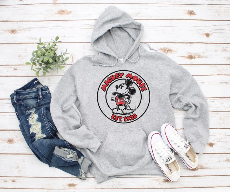 May include: A grey hooded sweatshirt with a black and white Mickey Mouse graphic and the text "Mickey Mouse Est. 1928".