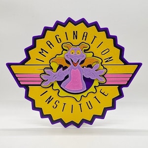 Könnte beinhalten: Lila und gelbes Logo des Imagination Institute mit einer lila Drachenfigur in der Mitte. Das Logo ist ein stilisierter Sternenausbruch mit den Worten "Imagination Institute" am Rand.