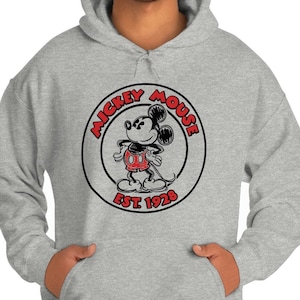 May include: A grey hooded sweatshirt with a black and white circle graphic featuring Mickey Mouse in red shorts. The circle graphic says "Mickey Mouse Est. 1928".