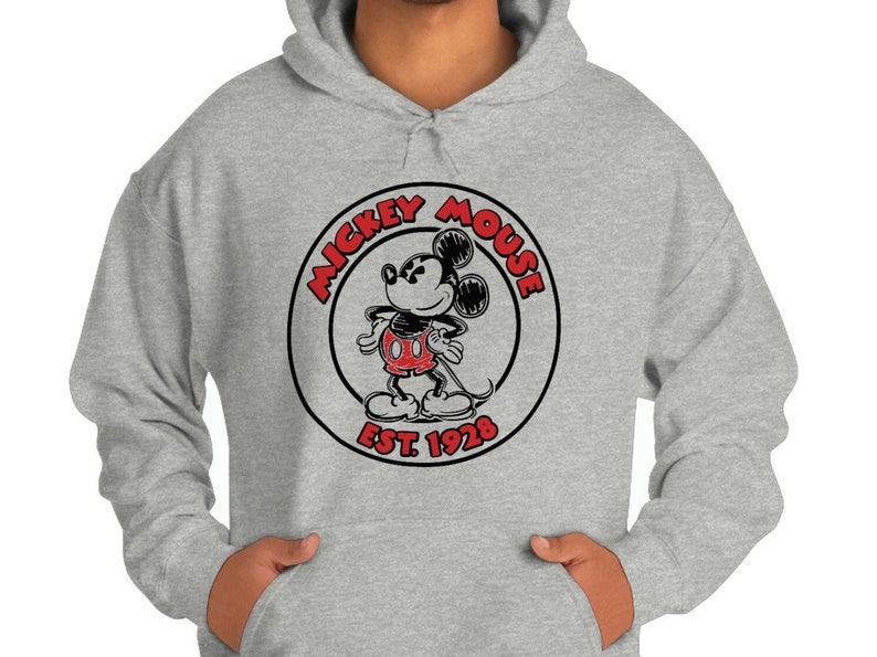 May include: A grey hooded sweatshirt with a black and white circle graphic featuring Mickey Mouse in red shorts. The circle graphic says "Mickey Mouse Est. 1928".