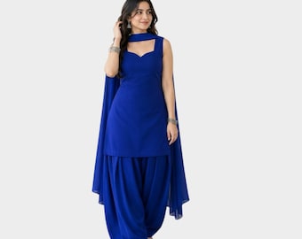 May include: A solid royal blue sleeveless kurta with a sweetheart neckline, paired with matching pleated salwar pants and a long, flowing dupatta draped over the shoulders. The ensemble features a consistent deep blue color throughout the entire set.