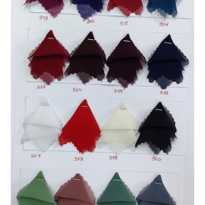 Puede incluir: Una carta de colores de tela con diecis&eacute;is muestras de tela triangulares dispuestas en cuatro filas. Cada muestra est&aacute; sujeta a una tarjeta blanca y etiquetada con un n&uacute;mero del 949 al 964. Las muestras muestran una variedad de colores, incluidos tonos rojos, azules, verdes, blancos, negros y marrones.