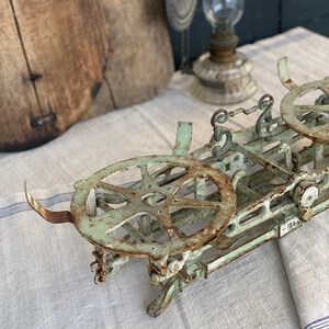 Pu&ograve; includere: Una bilancia vintage in metallo verde con due piattaforme circolari. La bilancia ha una finitura arrugginita ed &egrave; in buone condizioni.