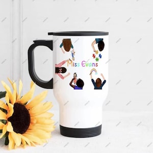 May include: White travel mug with a black handle and lid. The mug features illustrations of children and the text "Miss Evans" in a colorful font. A yellow sunflower is in the foreground.