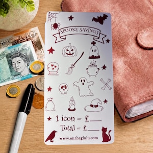 Peut inclure: Une carte de suivi d'épargne rectangulaire blanche avec des icônes rouge foncé sur le thème d'Halloween, dont une citrouille, une pierre tombale, un balai, un chaudron, un fantôme, un crâne et un chapeau de sorcière. Texte : Spooky Savings.