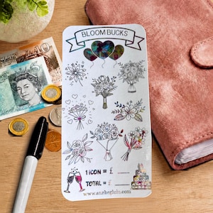 Peut inclure: Une feuille d'autocollants rectangulaire blanche intitulée BLOOM BUCKS avec des illustrations holographiques de bouquets de fleurs, de ballons en forme de cœur, de deux coupes de champagne et d'un gâteau à étages, incluant le site anrhegluia.com.