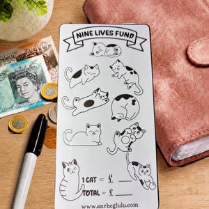 Peut inclure: Une carte de suivi d'épargne rectangulaire blanche intitulée NINE LIVES FUND avec des illustrations au trait noir de neuf chats dans diverses poses. La carte comprend des champs pour 1 CAT = £ et TOTAL = £, ainsi que l'adresse www.anrheglulu.com.