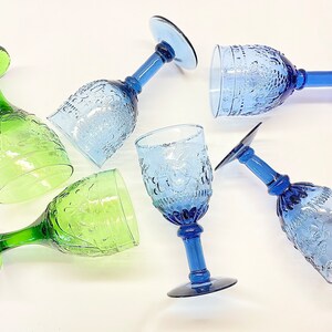 May include: Six vintage glass goblets in green and blue colours. The goblets have a textured design and are perfect for serving wine or other beverages.