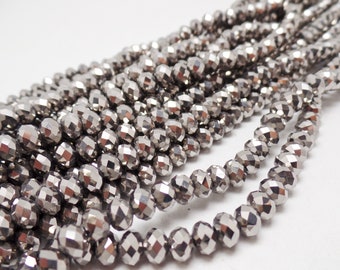 May include: A strand of silver faceted beads. The beads are round and have a shiny, metallic finish.