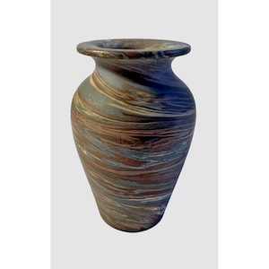 May include: A decorative vase with a wide base and a narrow neck. The vase features a swirling pattern of brown, blue, and cream colours. The vase is approximately 25 cm tall and 15 cm wide at its widest point.