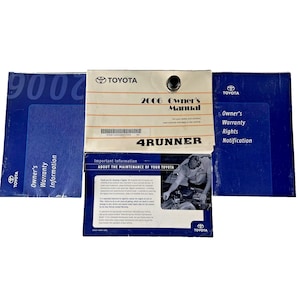 May include: A set of Toyota 4Runner manuals and warranty information booklets. The 2006 Owner's Manual is cream-colored with black text and a black fastener. The other booklets are blue with white text. The Toyota logo is visible.