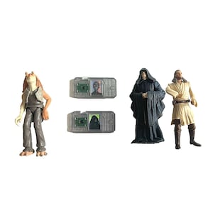 Könnte beinhalten: Eine Sammlung von Star Wars-Actionfiguren, darunter Jar Jar Binks, Darth Sidious und Qui-Gon Jinn. Ebenfalls enthalten sind zwei kleine, transparente, rechteckige Geräte mit Charakterbildern. Die Figuren stehen vor weißem Hintergrund.