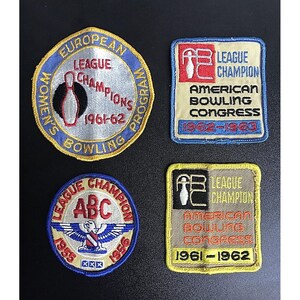 May include: Four vintage bowling patches. One patch reads "Women's European League Champions 1961-62 Bowling Program". Two patches say "League Champion American Bowling Congress" with years 1962-1963 and 1961-1962. The last patch says "League Champion ABC 1955-1956".