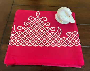 May include: A red fabric square with a white geometric design. The design features a repeating pattern of diamonds and circles. The fabric is folded in half and has a white label with the text "Creative Fabrics USA".