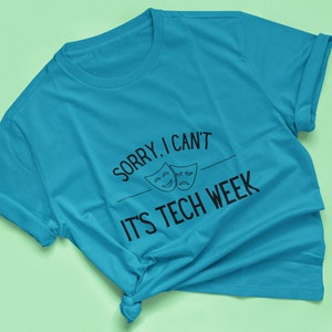Puede incluir: Una camiseta azul turquesa con el texto "Lo siento, no puedo, es la semana de la tecnolog&iacute;a" y dos m&aacute;scaras de teatro en blanco y negro.