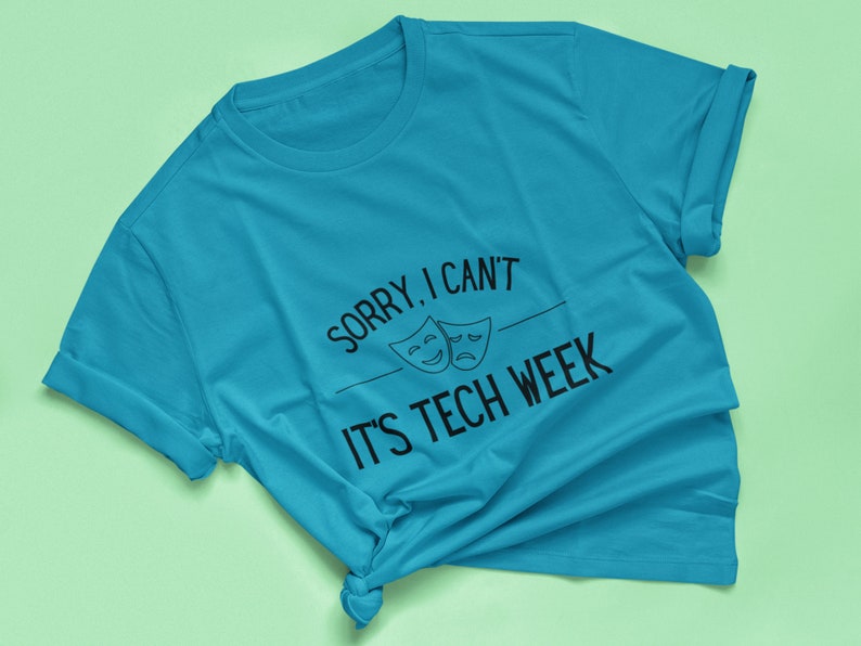 Puede incluir: Una camiseta azul turquesa con el texto "Lo siento, no puedo, es la semana de la tecnolog&iacute;a" y dos m&aacute;scaras de teatro en blanco y negro.