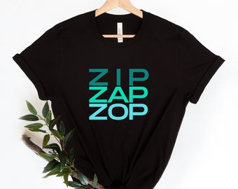 Puede incluir: Camiseta negra con un estampado gráfico de las palabras "ZIP ZAP ZOP" en un degradado de verde y azul.