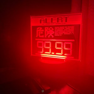 May include: A red digital display with the word "ALERT" and the text "危险" in Chinese characters. The display also shows the number "99.99".