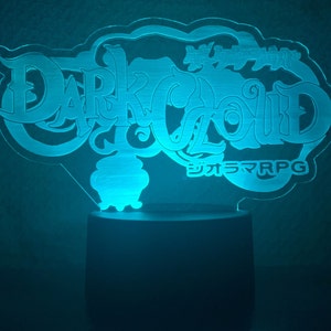 May include: A blue light-up sign with the words "Dark Cloud" and "シエラRPG" in Japanese. The sign is shaped like a cloud and has a cauldron in the center.