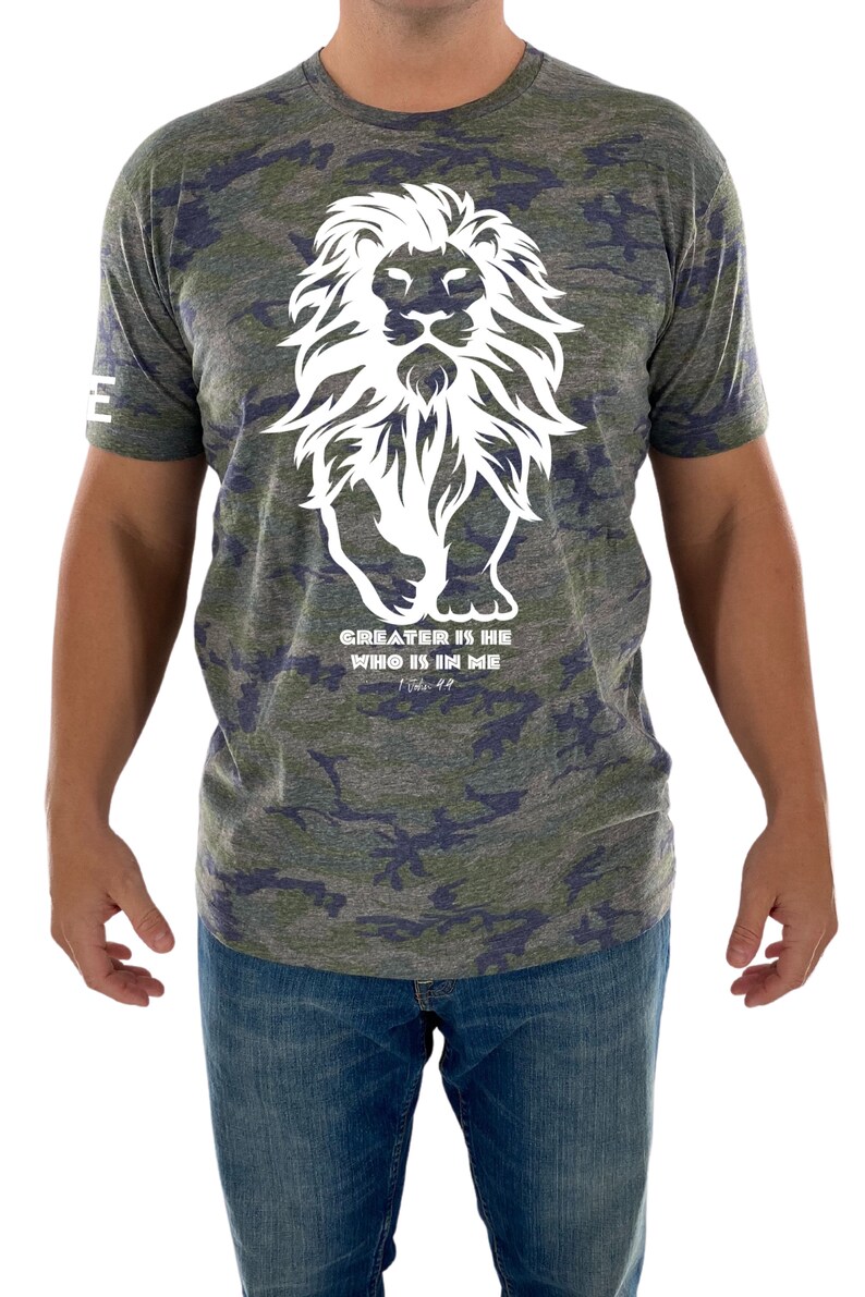 May include: A green, blue, and gray camouflage t-shirt with a white lion graphic and the text "GREATER IS HE WHO IS IN ME 1 John 4:4".