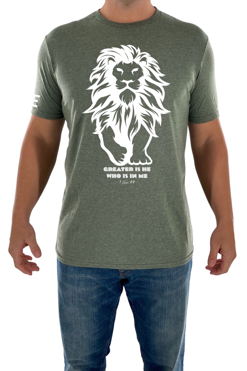 May include: A green t-shirt with a white lion graphic and the text "GREATER IS HE WHO IS IN ME" with the scripture reference "1 John 4:4".