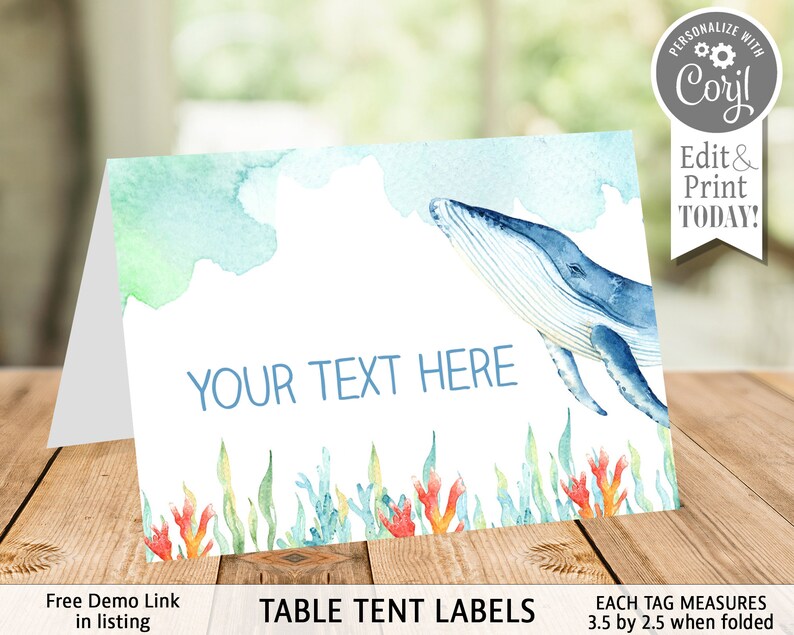 May include: Table tent labels with a watercolor background featuring a blue whale swimming in the ocean. The labels are 3.5 inches by 2.5 inches when folded and have the text "YOUR TEXT HERE" printed on them.