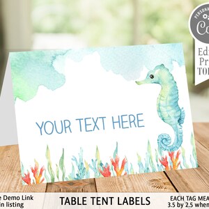 May include: A folded table tent card with a watercolor design. The card features a blue seahorse, coral, and seaweed illustrations. The text "YOUR TEXT HERE" is displayed in blue. The card measures 3.5 by 2.5 inches when folded. The text "TABLE TENT LABELS" is also displayed.