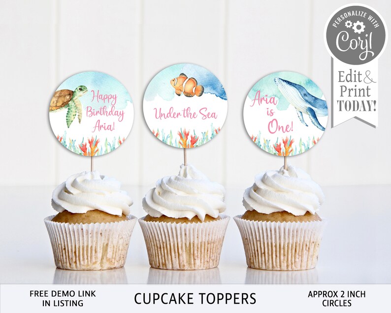 May include: Three cupcake toppers featuring an under the sea theme. The toppers are 2 inches in diameter and feature a sea turtle, a clownfish, and a whale. The toppers are printed on white cardstock and have a watercolour effect.