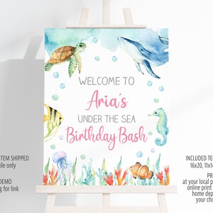 May include: A printable welcome sign for a birthday party with an under the sea theme. The sign features a blue whale, a sea turtle, a seahorse, a jellyfish, and a clownfish. The text on the sign reads "Welcome to Aria's Under the Sea Birthday Bash".