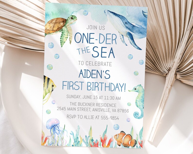 May include: A blue and white watercolor invitation for a first birthday party with the text "Join us One-Der the Sea to celebrate Aiden's First Birthday!"  The invitation features a whale, a sea turtle, a seahorse, a jellyfish, and a clownfish.