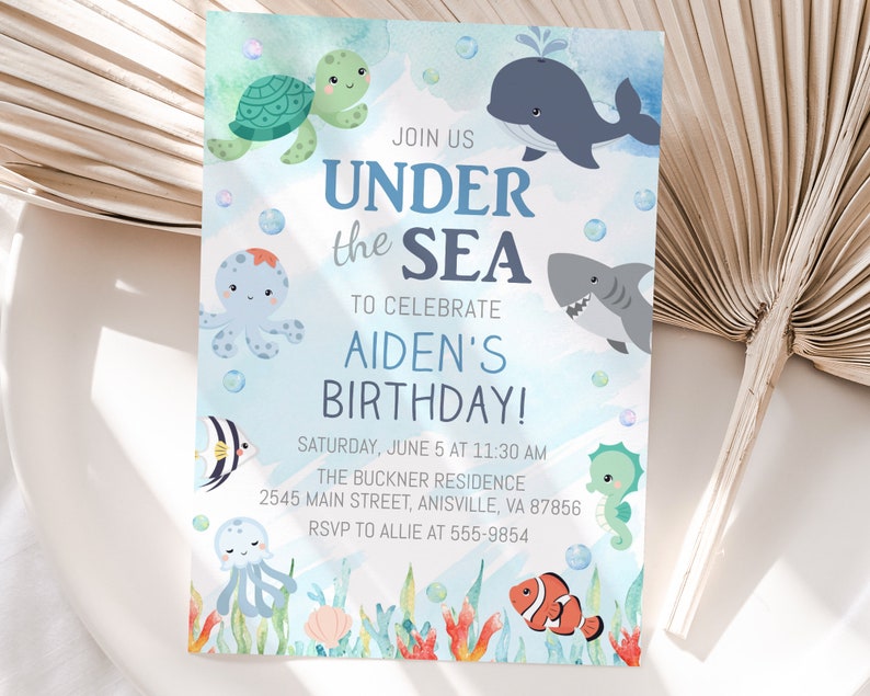 May include: A blue and white invitation card with a watercolor background featuring sea creatures like a turtle, octopus, whale, shark, and seahorse. The text on the card reads "Join us Under the Sea to celebrate Aiden's Birthday!" with details about the event.