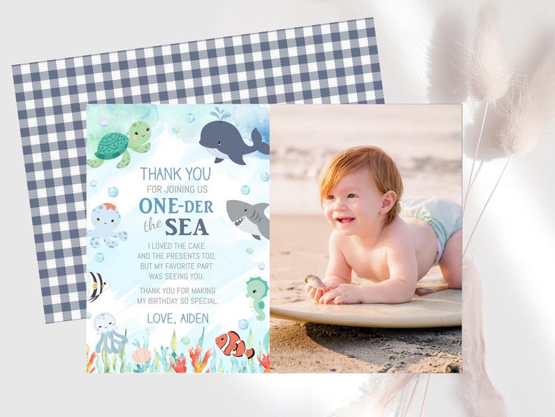 The image is a birthday card for a baby, featuring a beach scene with a baby lying on a surfboard and surrounded by sea creatures. The card also includes a photo of a smiling baby.