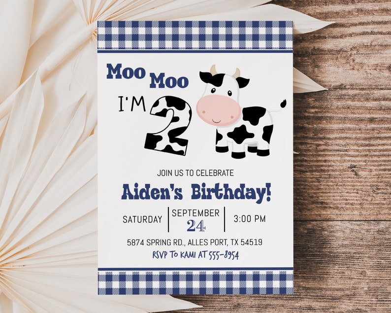 K&ouml;nnte beinhalten: Eine Einladung mit wei&szlig;-blauem Karomuster und einer Illustration einer schwarz-wei&szlig;en Kuh. Der Text lautet "Moo Moo I'm 2" und "Aiden's Birthday!" mit Details zur Party.