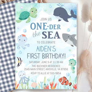 May include: A birthday party invitation with an ocean theme. The invitation features cartoon sea creatures, including a turtle, whale, shark, and seahorse. The text reads "ONE-DER the SEA" and announces a first birthday celebration.