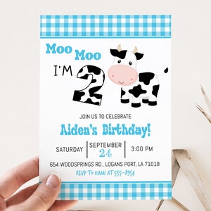 May include: A blue and white gingham birthday invitation featuring a cartoon cow and the text "Moo Moo I'm 2" and "Aiden's Birthday!" The invitation includes the date, time, and location of the party.