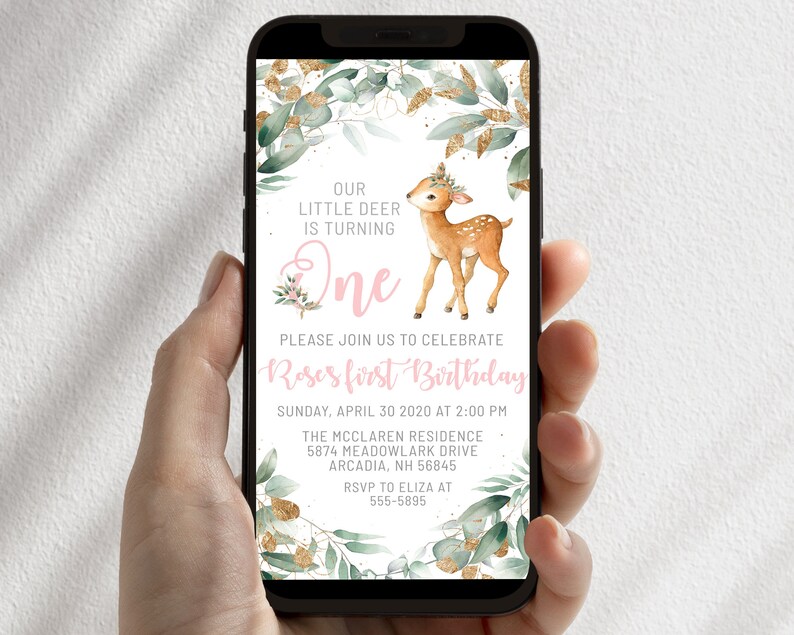 May include: A digital invitation for a first birthday party featuring a cute fawn illustration. The invitation is decorated with green leaves and gold glitter. The text reads "Our little deer is turning one. Please join us to celebrate Roses first birthday. Sunday, April 30 2020 at 2:00 PM. The McClaren Residence 5874 Meadowlark Drive Arcadia, NH 56845. RSVP to Eliza at 555-5895."