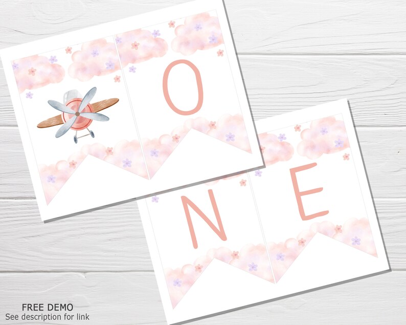 K&ouml;nnte beinhalten: Rosa-wei&szlig;er druckbarer Banner mit dem Wort "ONE" in rosa Buchstaben. Der Banner zeigt ein Aquarelldesign mit Wolken und Blumen. Ein kleines Flugzeug ist auf dem ersten Banner abgebildet.