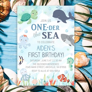 May include: A blue and white invitation with the text "ONE-DER the SEA" and "AIDEN'S FIRST BIRTHDAY!". The invitation features cartoon illustrations of sea creatures, including a turtle, whale, shark, and seahorse. The invitation is surrounded by seashells.