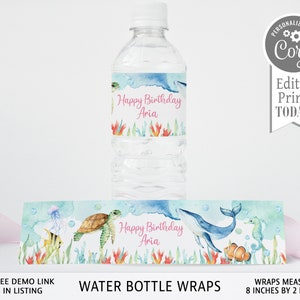 May include: Water bottle labels with an under the sea theme. The labels feature a whale, seahorse, turtle, and coral. The text on the labels reads "Happy Birthday Aria". The labels measure 8 inches by 2 inches.