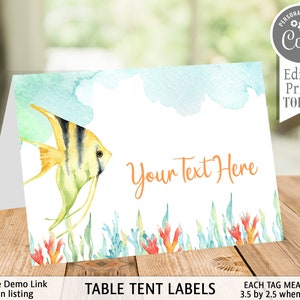 May include: A folded table tent card with a watercolor design. It features a yellow and black striped fish, coral, and seaweed. The text "Your Text Here" is in orange. The card measures 3.5 by 2.5 inches when folded.