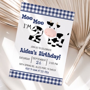 K&ouml;nnte beinhalten: Eine Einladung mit blau-wei&szlig;em Karomuster mit einer Comic-Kuh und dem Text "Moo Moo I'm 2" und "Aiden's Birthday!"  Feiern Sie mit uns am Samstag, den 24. September um 15:00 Uhr. 5874 Spring Rd., Alles Port, TX 54519. RSVP an Kami unter 555-8954.